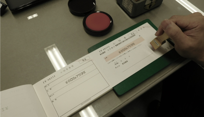 小切手に印を押す様子