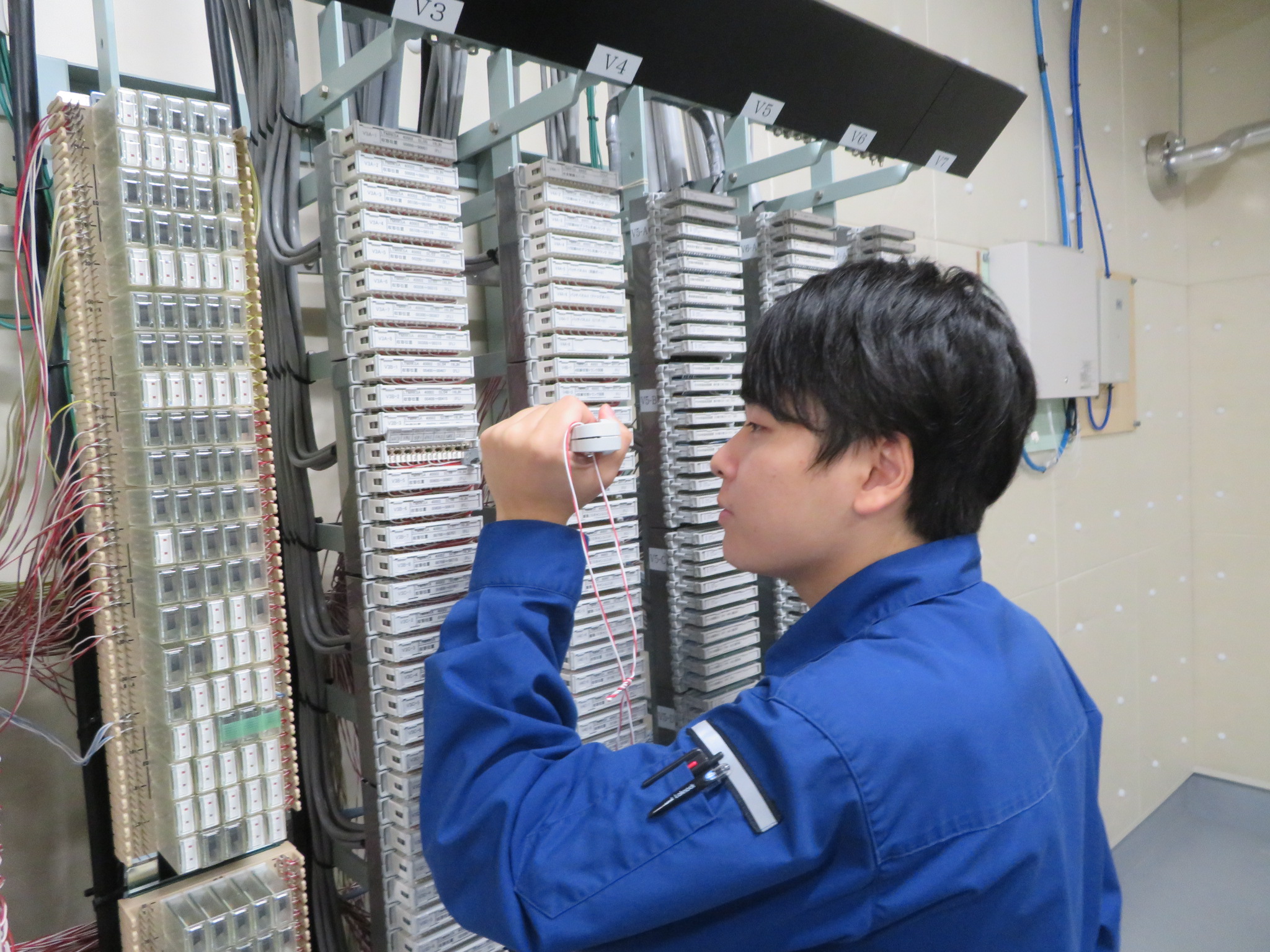 機器に向かって作業をする男性技官の写真